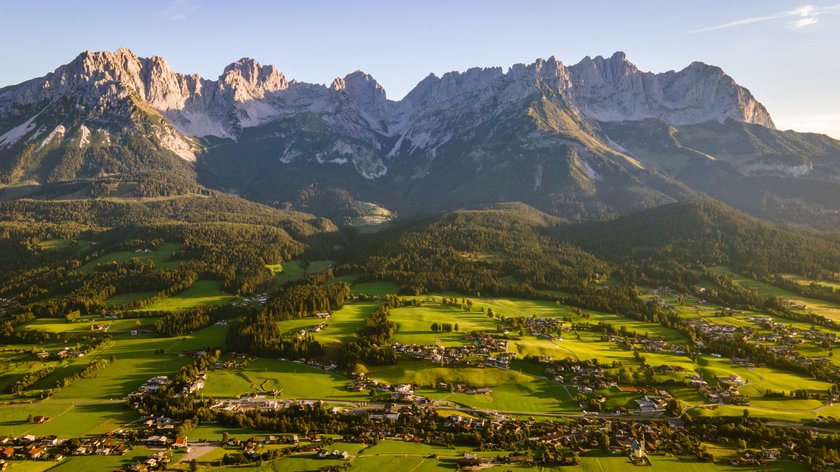 Wanderparadies am Wilden Kaiser Blick auf grüne Landschaft und Bergkette im Gegenlicht