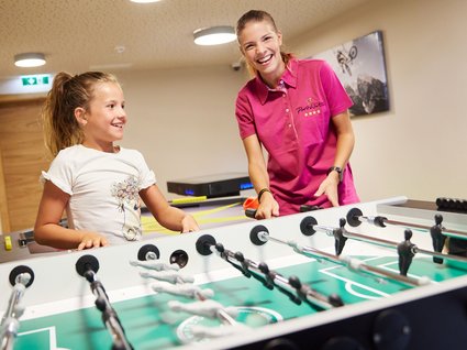 Zwei Mädchen spielen Tischfußball Zwei Mädchen spielen fröhlich Tischfußball in einem Indoor-Spielbereich des Hotels.
