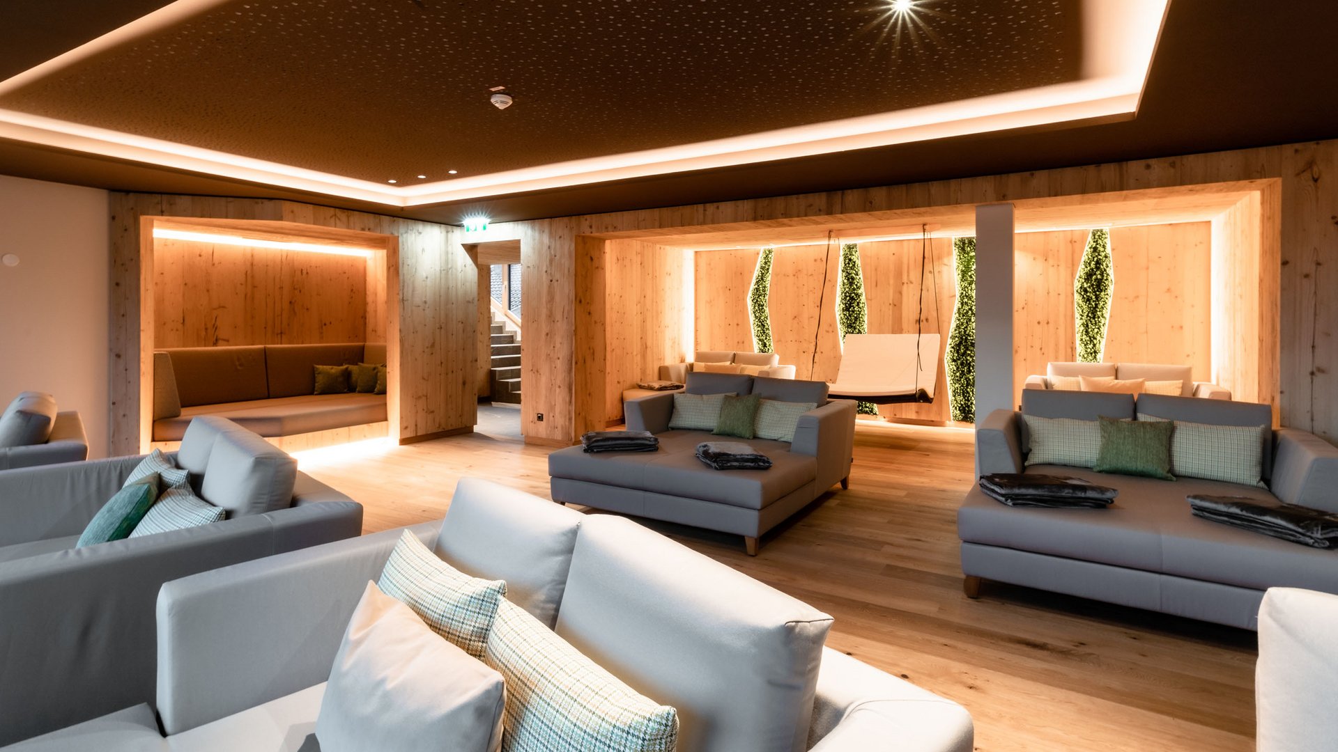 Hotel in Söll am Wilden Kaiser: der Postwirt Moderner Ruheraum mit Sofas, Holzwänden und sanfter Beleuchtung