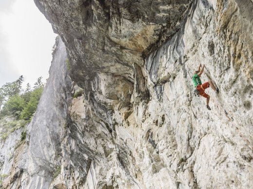 Sommer am Wilden Kaiser: Wandern und mehr Kletterer an steiler Felswand mit Sicherungsseil und Wasserfall