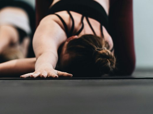 Ihr Urlaub im Yoga-Hotel in Tirol Frau in Sportkleidung macht Yoga-Stretching auf Matte im Innenbereich