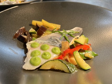 Kulinarische Verführungen in unserem Hotel in Söll/Tirol Fischfilet mit grüner Sauce und buntem Gemüse auf schwarzem Teller