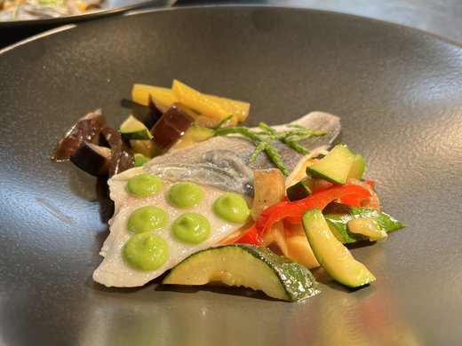 Kulinarische Verführungen in unserem Hotel in Söll/Tirol Fischfilet mit grüner Sauce und buntem Gemüse auf schwarzem Teller