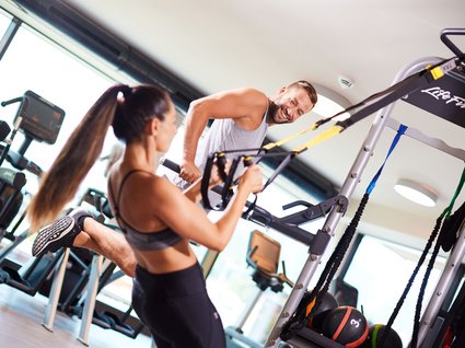 Sie suchen ein Wellnesshotel in Tirol für adults only? Mann und Frau trainieren mit TRX-Bändern im Fitnessstudio