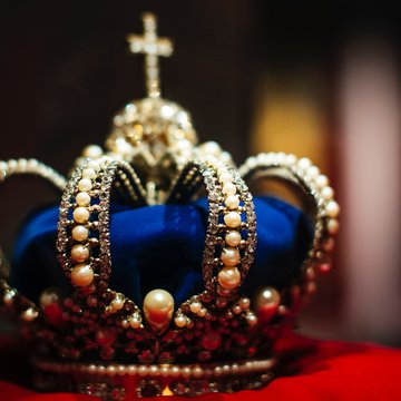 Urlaub in Söll mit Kindern oder als Pärchen Kleine Krone mit Perlen und Edelsteinen auf rotem Samtkissen