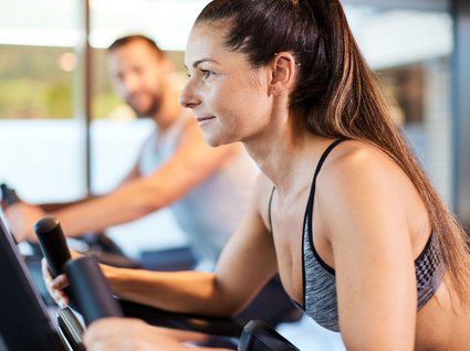 Sie suchen ein Hotel mit Fitnessstudio in Österreich? Frau und Mann trainieren auf Fahrradergometern im Fitnessstudio