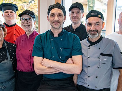Arbeiten im Postwirt Gruppenfoto von sieben Restaurantmitarbeitern in verschiedenen Uniformen
