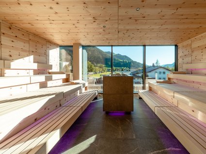 Day Spa in Söll: Kurzurlaub in Tirol Moderne Sauna mit Holzinterieur und Panoramablick auf Berge und Häuser