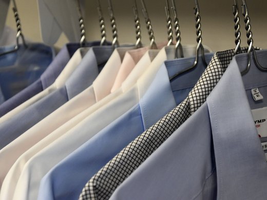 Unser Hotel in Söll/Österreich: eine spannende Geschichte Hängende Hemden in verschiedenen Farben und Mustern auf Kleiderbügeln