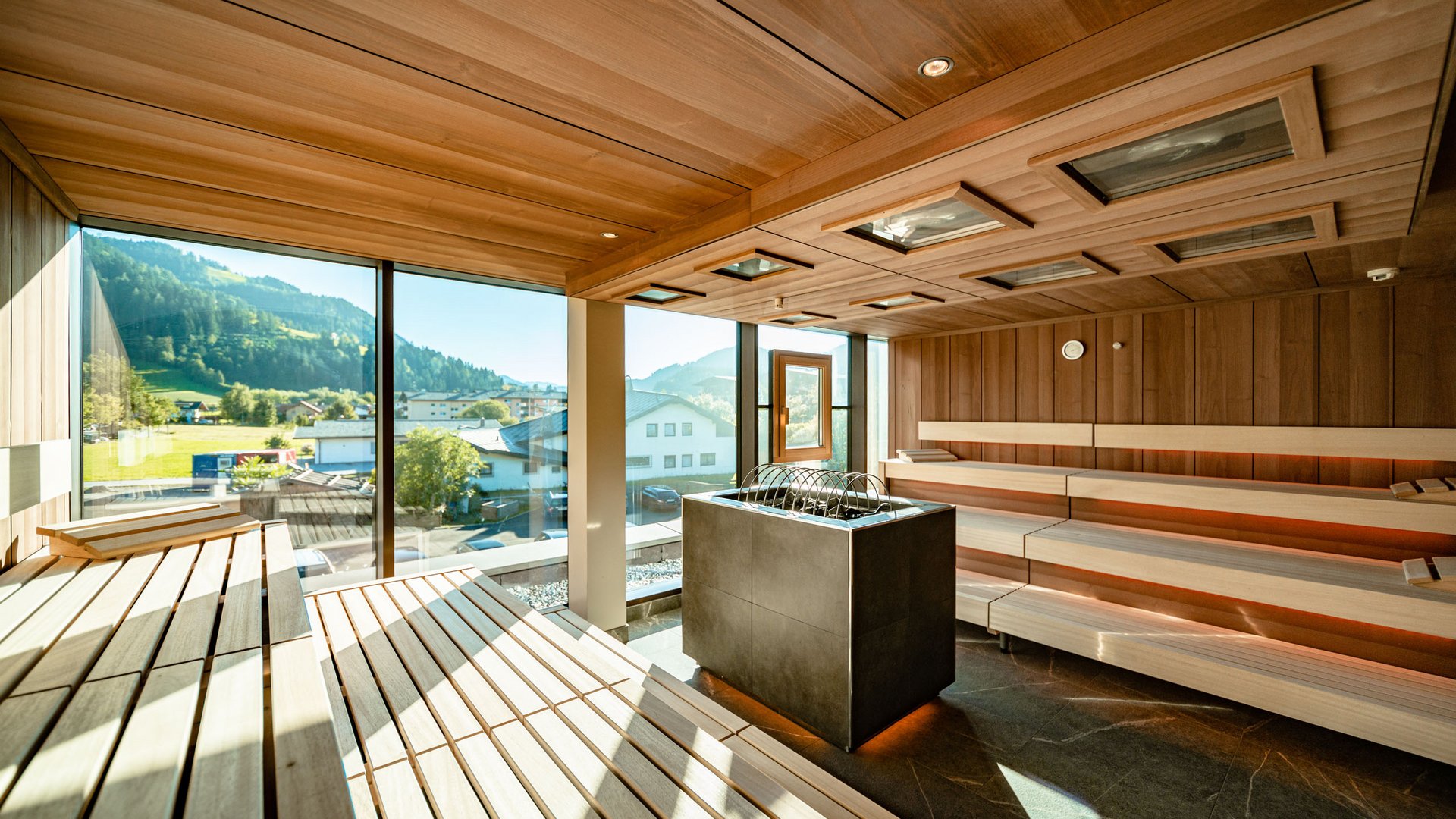 Hotel in Söll am Wilden Kaiser: der Postwirt Moderner Sauna-Innenraum mit Holzverkleidung und Bergblick durch große Fenster