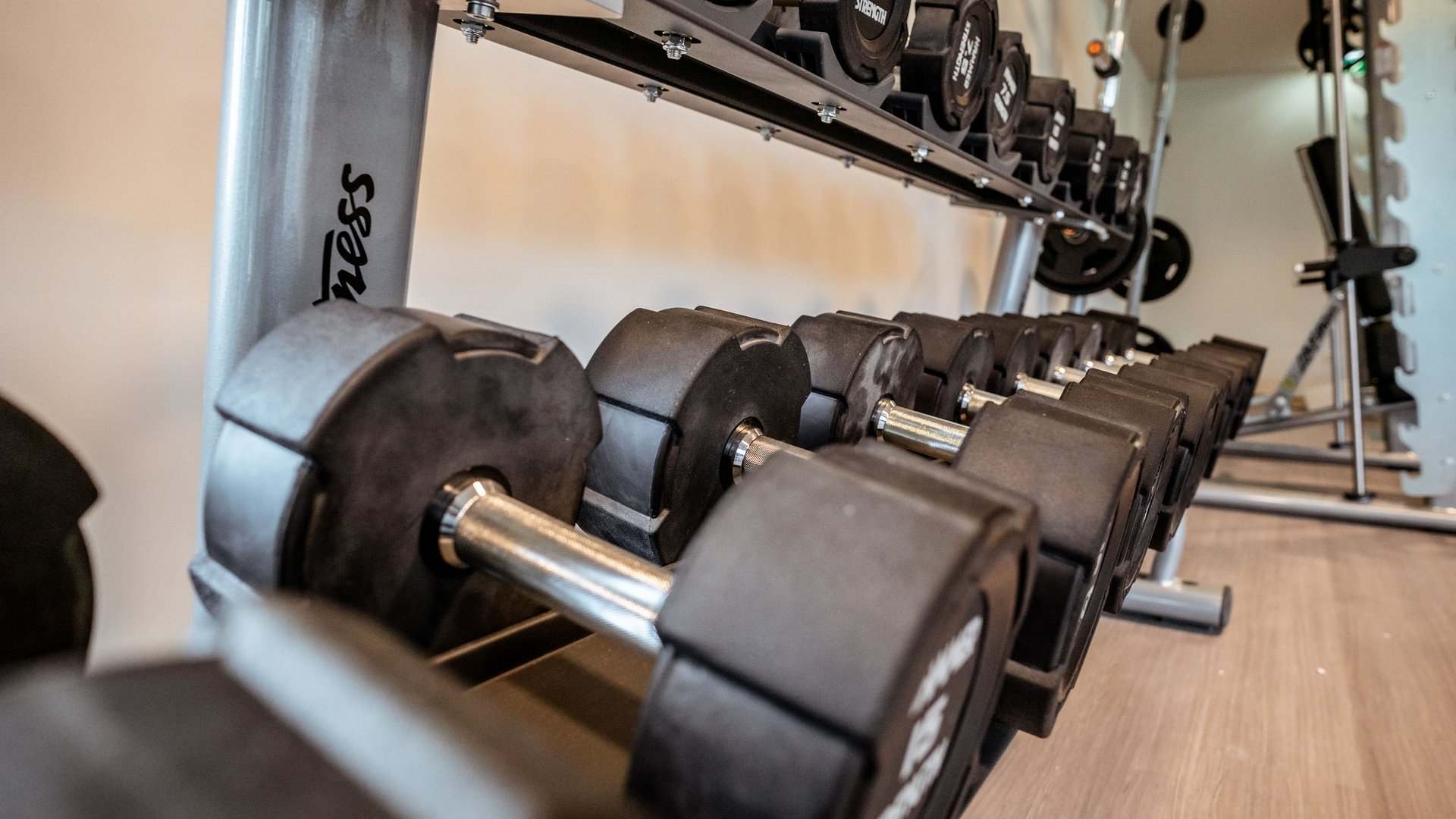 Sie suchen ein Hotel mit Fitnessstudio in Österreich? Reihe von schwarzen Kurzhanteln in einem Fitnessstudio