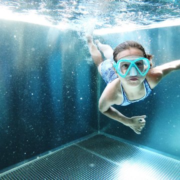 Urlaub in Söll mit Kindern oder als Pärchen Kind schwimmt unter Wasser in einem Pool mit Taucherbrille