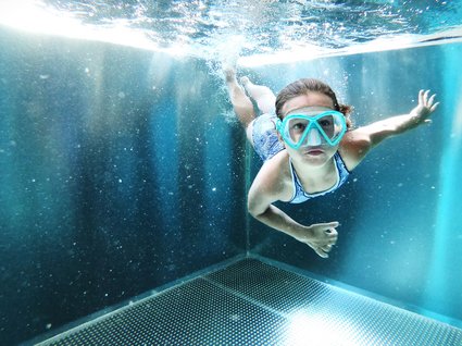 Der Postwirt: Hotel mit Infinitypool in Tirol Kind schwimmt unter Wasser in einem Pool mit Taucherbrille