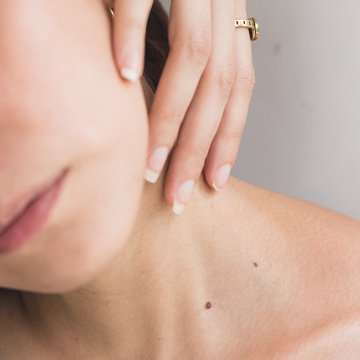 Urlaub in Söll mit Kindern oder als Pärchen Nahaufnahme von Frau mit Hand am Hals und sichtbaren Muttermalen