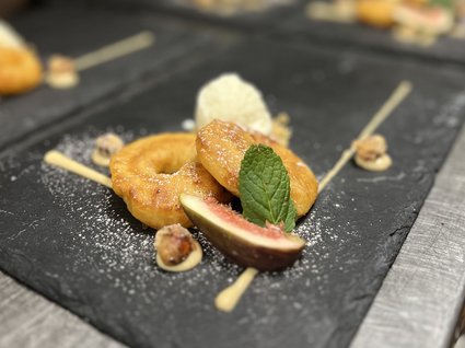 Kulinarische Verführungen in unserem Hotel in Söll/Tirol Kreativ angerichtetes Dessert mit kleinen Donuts, Feige, Minze und Nusssauce