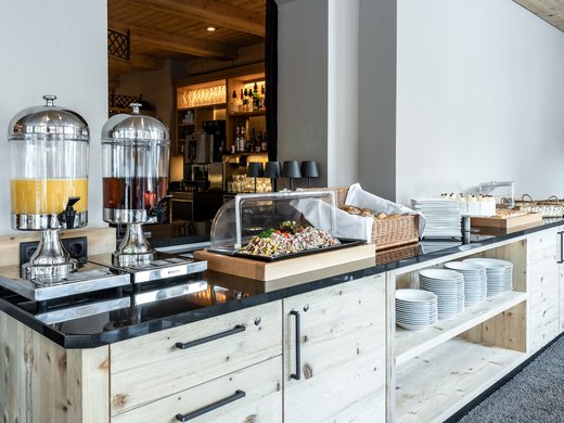 Frühstücksbuffet mit frischen Säften und Gebäck Buffet mit Saftspendern, Gebäck und Tellern in einem Hotelrestaurant