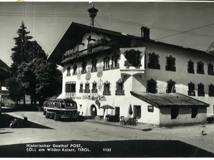 Unser Hotel in Söll/Österreich: eine spannende Geschichte Historischer Gasthof Post in Söll am Wilden Kaiser, Tirol mit altem Bus davor