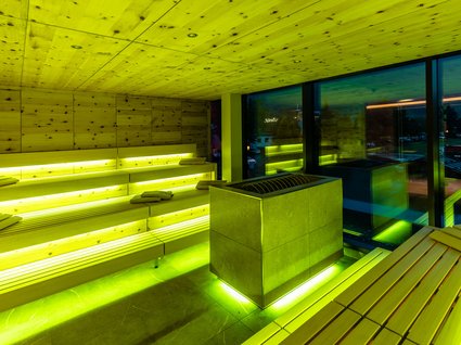 Moderne Sauna mit Panoramablick Moderne Sauna mit gelber Beleuchtung und Holzverkleidung am Abend